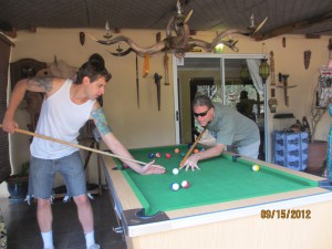 John and Nate playing pool (John's stick is a broom handle)